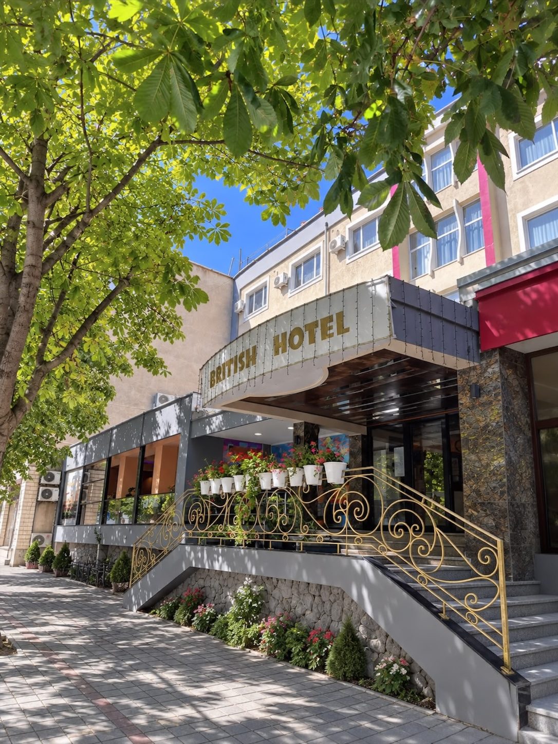 The entrance of British Hotel Pogradec on a sunny day